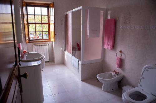 a bathroom with two sinks and a toilet and a shower at Casa dos Leões- Aldeia dos 4 abades in Ponte de Lima