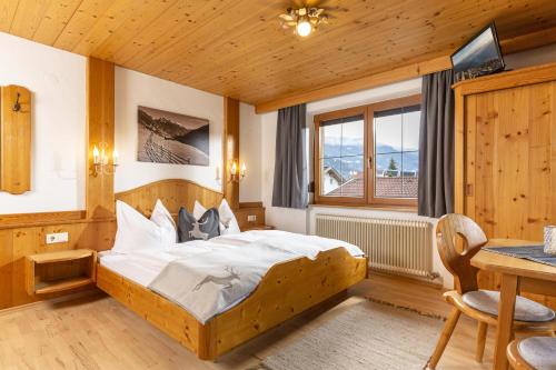 1 dormitorio con cama, mesa y ventana en Haus Jochler, en Ried im Zillertal