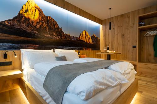 a bedroom with a large bed with a mountain mural at Teverone Suites & Wellness in Lamosano