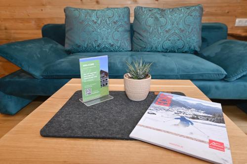 a coffee table with a blue couch in a living room at Salzgeber Appartements in Sankt Gallenkirch