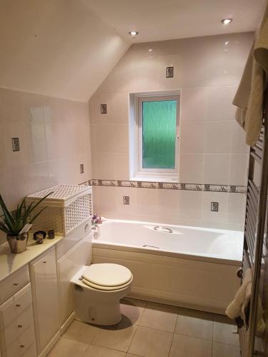 a bathroom with a tub and a toilet and a sink at Luxury Endon House Share in Endon