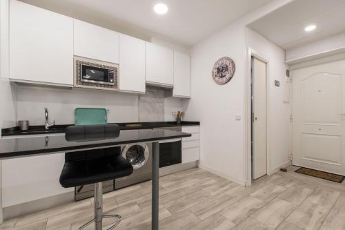 uma cozinha com armários brancos e uma máquina de lavar roupa em 4Torres Homes - Sofía em Madri