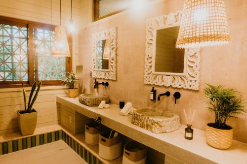 a bathroom with two sinks and a mirror at Tranquilseas Eco Lodge & Dive Center in Sandy Bay