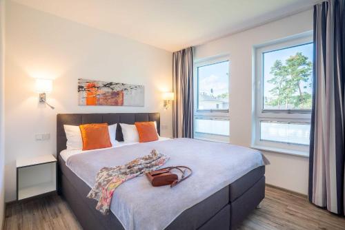 Appartement "Traumzeit" mit Penthouseflair - Oase am Haff في Garz: غرفة نوم بسرير كبير عليها محفظة نقود