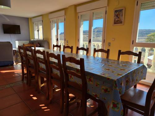a dining room with a table and chairs and windows at Casa de la Hiedra Soria in Soria