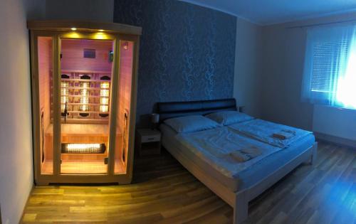 a bedroom with a bed and a glass cabinet at Csillagfény Apartment in Eger