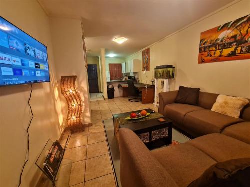 un soggiorno con divano e TV a schermo piatto di Menlyn Maine Apartments, Menlyn Place a Pretoria