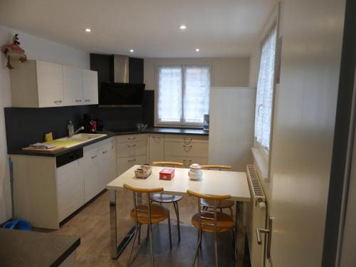 une cuisine avec une table et quelques chaises dans l'établissement Gite 'chez Cocotte', à La Bresse