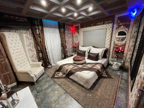 ein Schlafzimmer mit einem großen Bett und einem Stuhl in der Unterkunft Xcite Hotel Salem in Athen