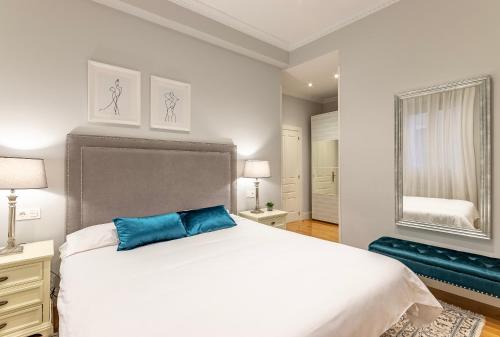 1 dormitorio con cama blanca grande y almohada azul en Amplio y Elegante en Casco Viejo con Parking, en Bilbao