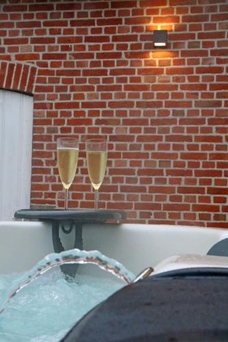 two glasses of champagne on a tray in a bath tub at Maison des Étoiles in Aalst