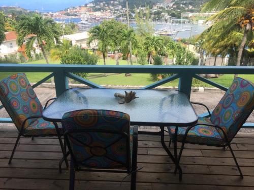 a table and two chairs on a balcony with a view at CasaCalypso Grenada in Belmont
