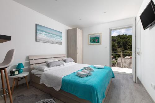 ein Schlafzimmer mit einem Bett mit Handtüchern auf einer blauen Decke in der Unterkunft SEAVIEW apartment SPARKLE ISKRA - Povlja, Brač in Povlja