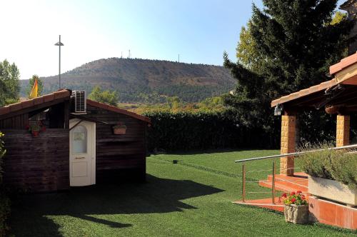 a smallshed with a white door in a yard at Casa de la Hiedra Soria in Soria