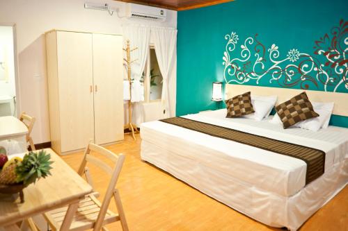 a bedroom with a large bed and a large window at Stingray Beach Inn in Maafushi