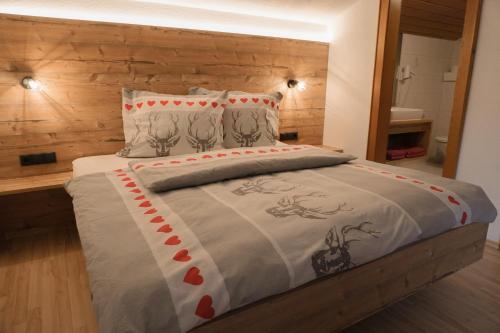 a bedroom with a bed with a wooden headboard at Apart Daniel in Ried im Oberinntal