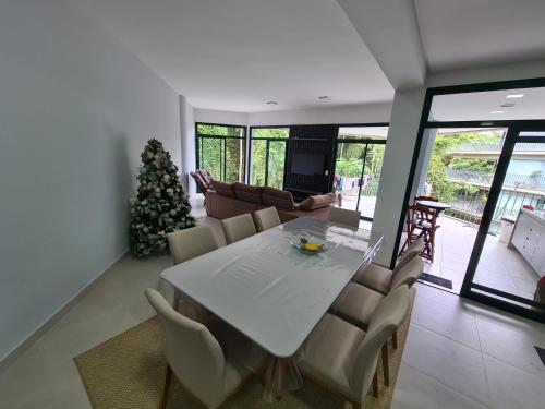 a dining room with a table and a christmas tree at Apartamento Ubatuba Reserva DNA in Ubatuba