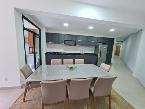 a kitchen and dining room with a table and chairs at Apartamento Ubatuba Reserva DNA in Ubatuba
