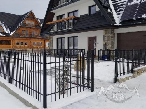 a black fence in front of a house at Bajeczna KoJa in Witów