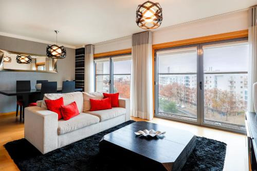 een woonkamer met een witte bank en rode kussens bij Oriente 57 Housing by APT IIN in Lissabon