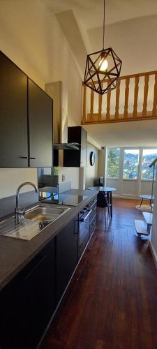 une cuisine avec un évier et une table à l'intérieur dans l'établissement L'Atypique Gérômois, à Gérardmer