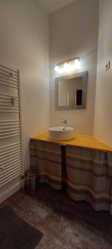 une salle de bain avec un lavabo et un miroir dans l'établissement L'Atypique Gérômois, à Gérardmer