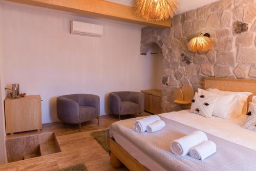 a hotel room with a bed and two chairs at Cappadocia Naif Hotel - Adults Only in Goreme