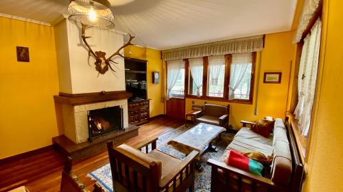 Casa Fresneda في Fresneda: غرفة معيشة بجدران صفراء ومدفأة