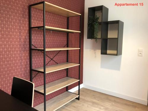 a black book shelf in a room with a wall at Les appartements du quai in Dieppe