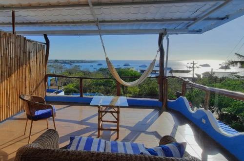 a porch with a hammock and a view of the ocean at Galápagos Casa Playa Mann in Puerto Baquerizo Moreno