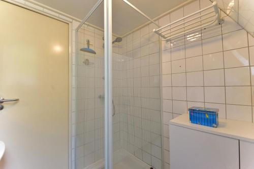 une douche avec une porte vitrée dans une salle de bain dans l'établissement Chalet 126 - Durbuy, à Durbuy