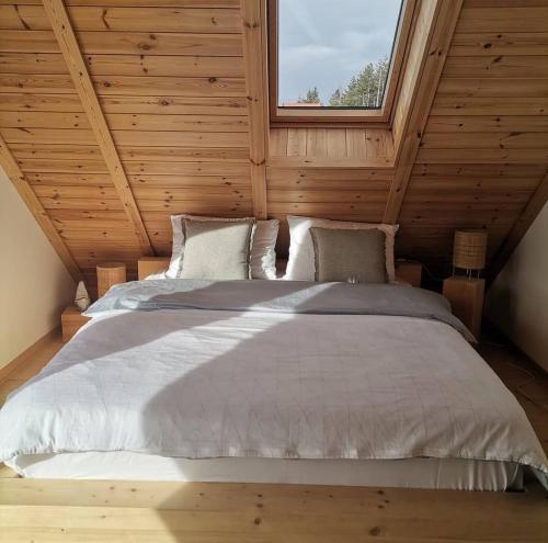 a bed in a wooden room with a window at Cortina resort in Ivanjica