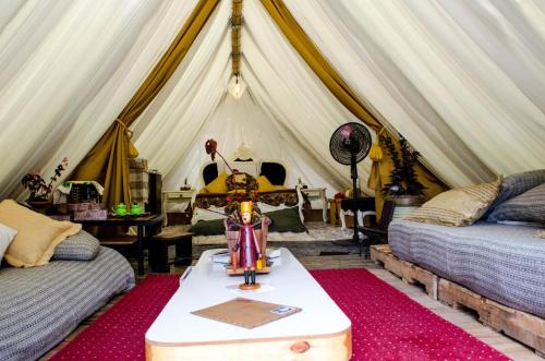 a room with a tent with two beds and a table at Glamping Tierra Dulce in Supatá