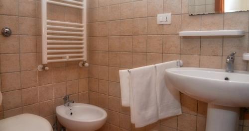 a bathroom with a white sink and a toilet at La Piana degli Ulivi in Ostuni