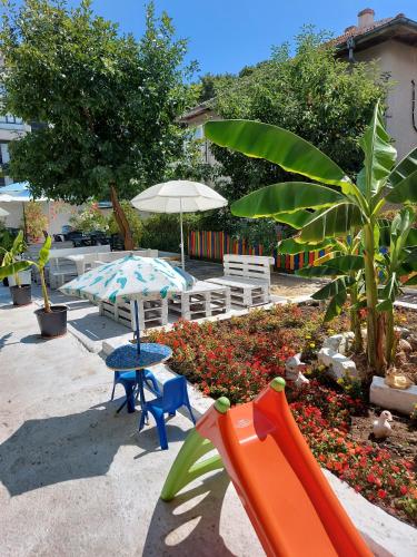 a patio with a table and chairs and an umbrella at Diamond Kiten in Kiten