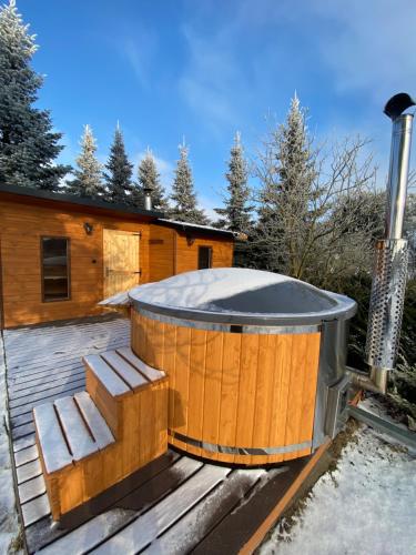a hot tub on the deck of a cabin at Dom Malowy Sad in Zalesie