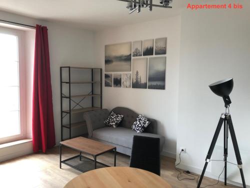 a living room with a couch and a table at Les appartements du quai in Dieppe