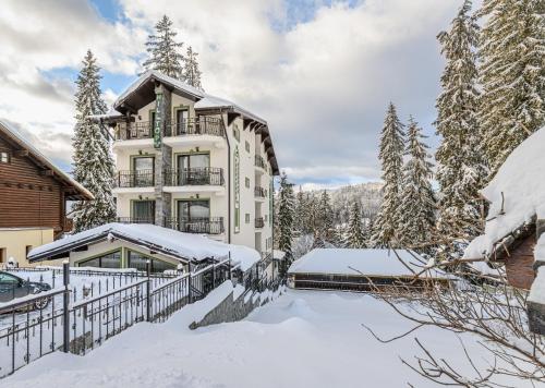 a house in the snow with a fence at Pensiunea Hilltop in Predeal