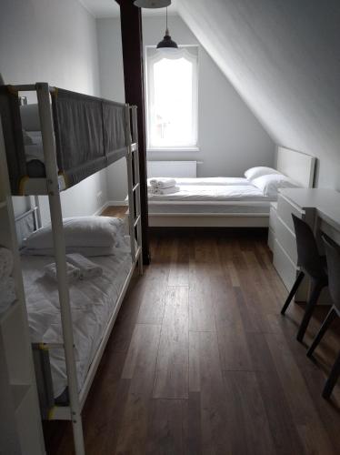 a room with bunk beds and a table and a window at Familijny in Toruń