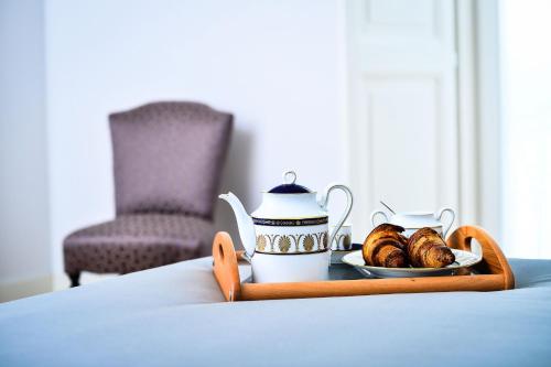 a tray with a tea kettle and croissants on a table at Camera A Sud in Bovino