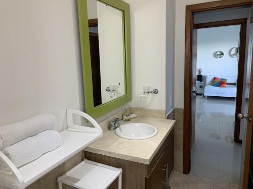 une salle de bain avec un lavabo et un miroir dans l'établissement Hermoso y amplio apartamento en Cartagena de Indias, à Carthagène des Indes