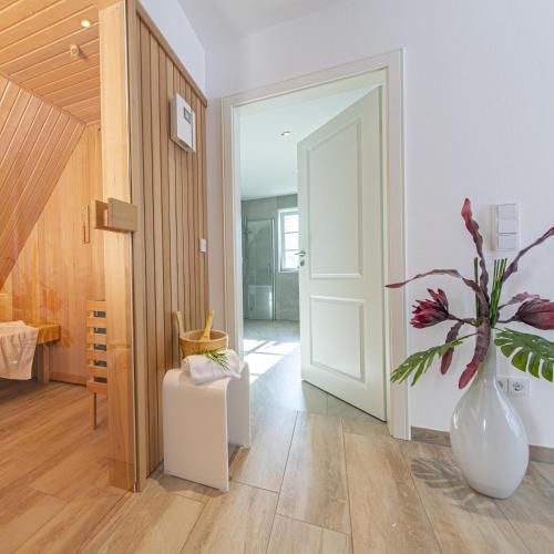 a hallway with a white door and a vase with a plant at Ferienhaus Koellers Hus in Böhl