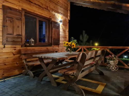 a wooden table and a bench on a patio at Siedlisko na Wzgórzu - Noclegi Agroturystyka - Borsuki in Sarnaki