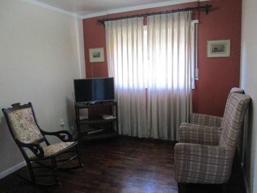 sala de estar con silla y TV en Depto para 4 personas Centro Salta capital en Salta