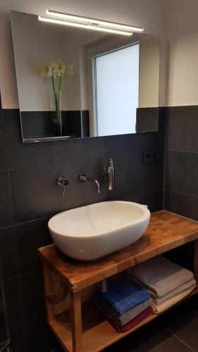 a bathroom with a white sink and a mirror at Stadtnahe Wohnung mit Garten und Parkplatz in Oldenburg