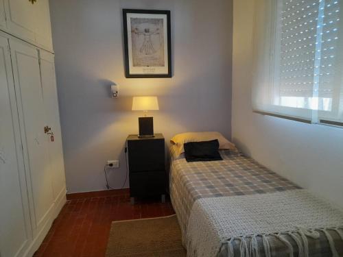 a bedroom with a bed and a lamp and a window at Departamento céntrico, en peatonal, con terraza in Concordia