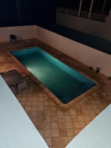 a swimming pool on a tiled floor with a table at Kmi in Zarzis