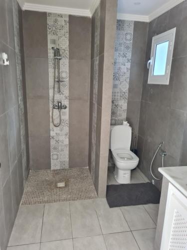 uma casa de banho com um chuveiro e um WC. em Kmi em Zarzis