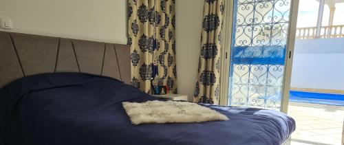 a bedroom with a blue bed with a pillow on it at Kmi in Zarzis