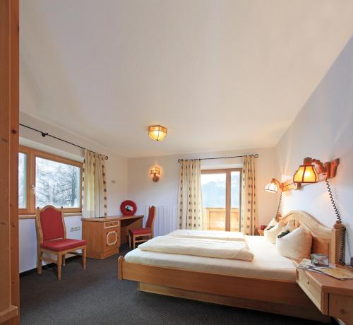 um quarto com uma cama, uma secretária e cadeiras em Residenz Scherrhof em Kirchberg in Tirol
